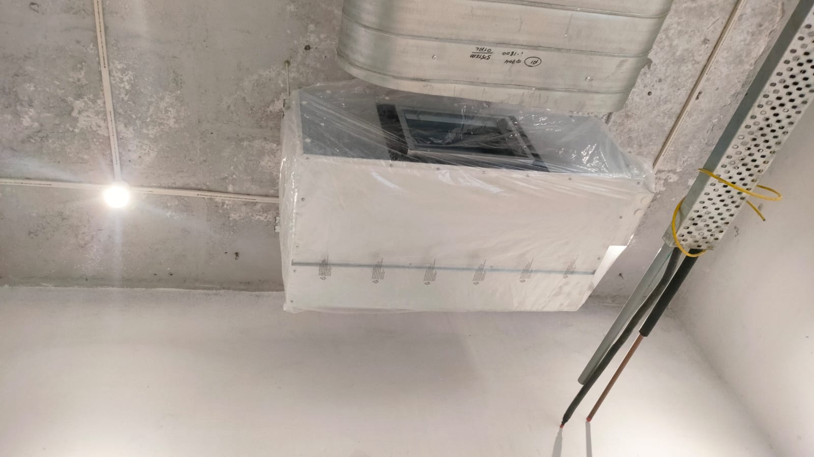 A white box illuminated by a light positioned on top, creating a bright focal point in the image.