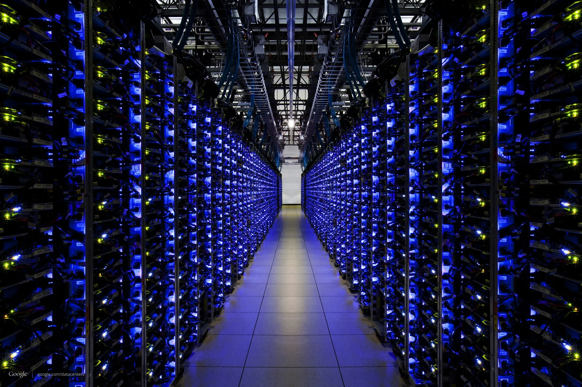 Interior of a data center with rows of servers illuminated in blue light, creating a futuristic and technology-driven atmosphere.